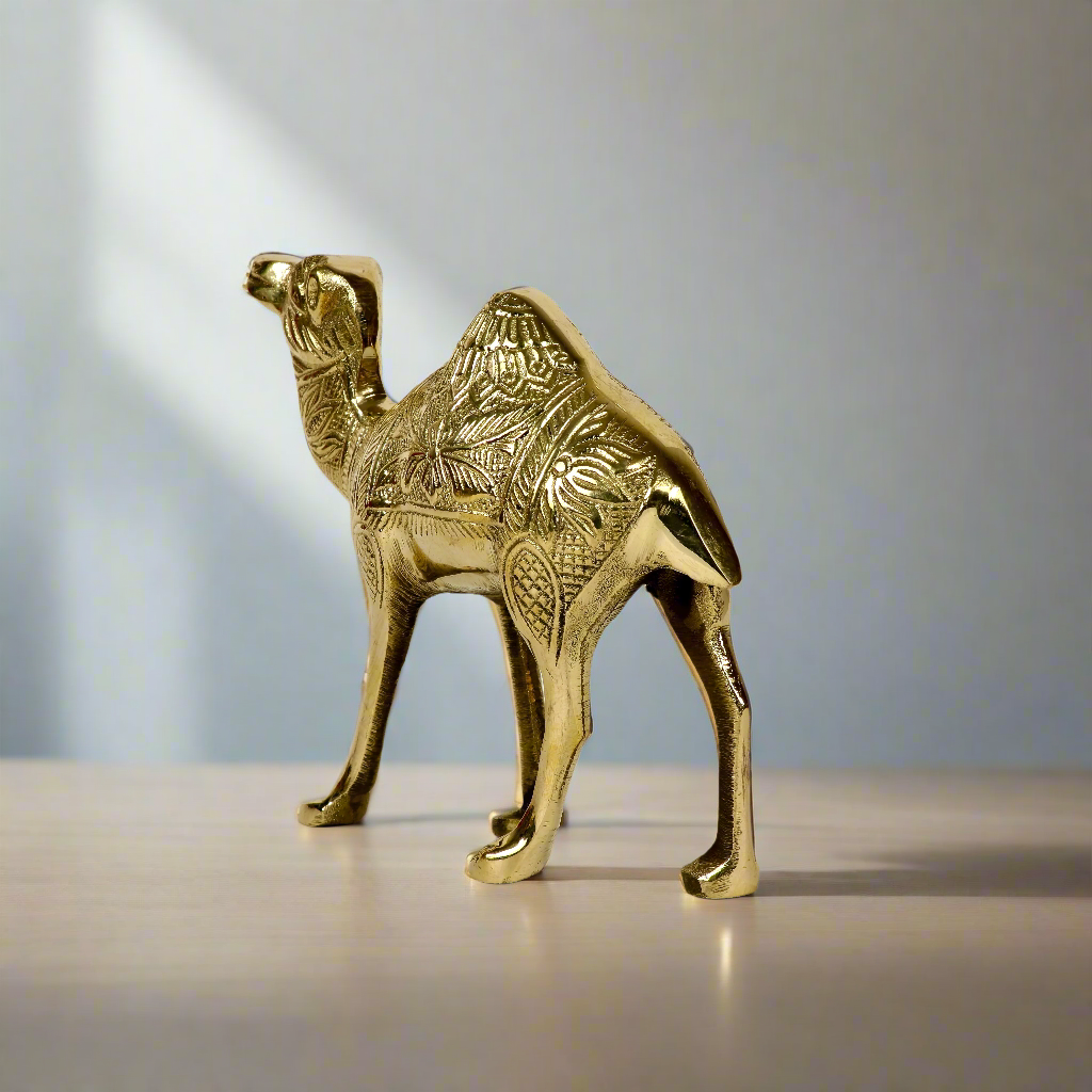 Product image of a Brass Camel figurine from Indian Impressions, intricately crafted with detailed features. The camel is depicted in a standing posture, symbolizing endurance and strength. Finished with a polished brass shine, this decorative piece is ideal for Vastu, home décor, or gifting.