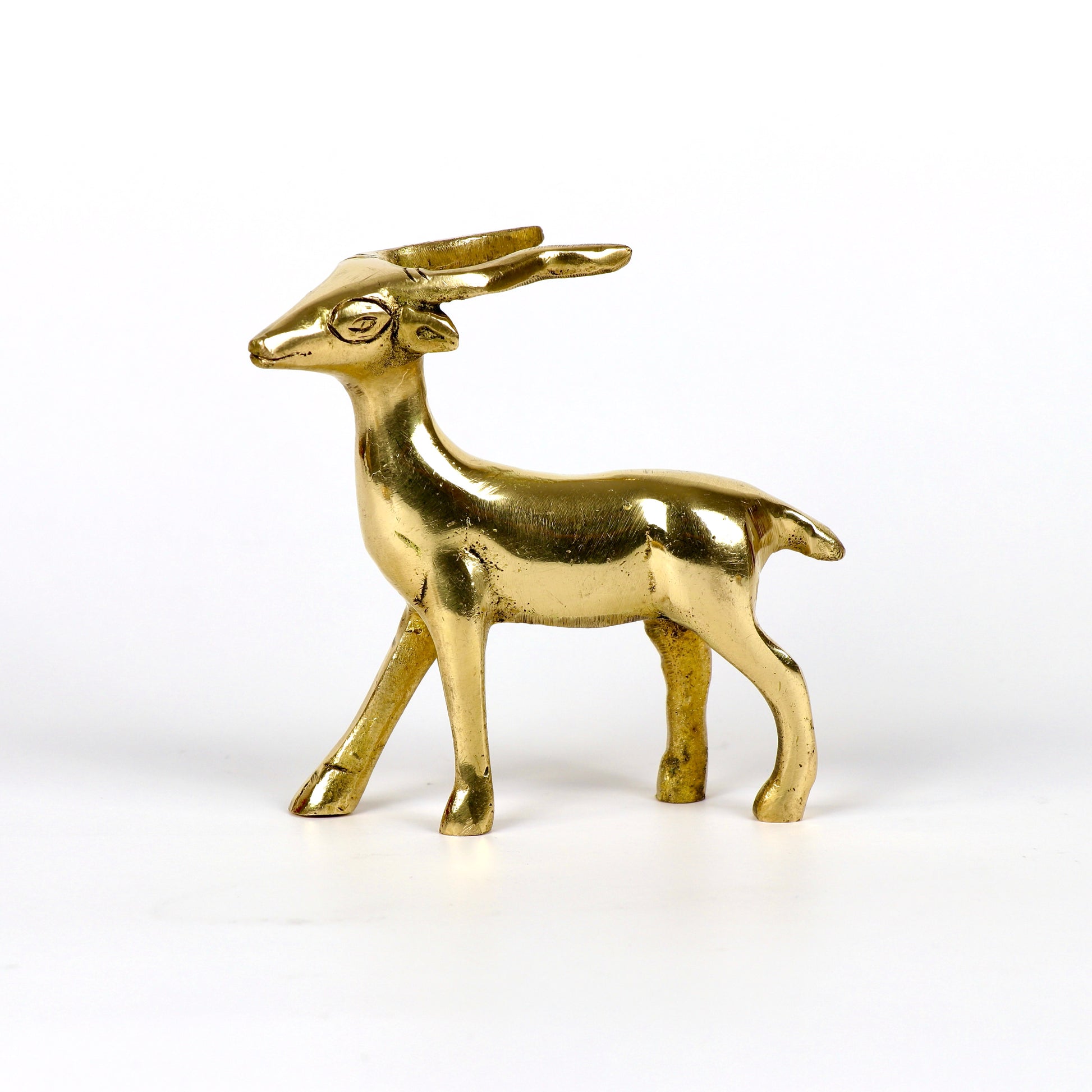 Image of a brass deer statue, elegantly designed with intricate detailing. The deer is depicted in a graceful standing posture, symbolizing peace, harmony, and gentleness. Crafted from polished brass, this statue is ideal for Vastu, home décor, or gifting to enhance positive energy and elegance in any space.