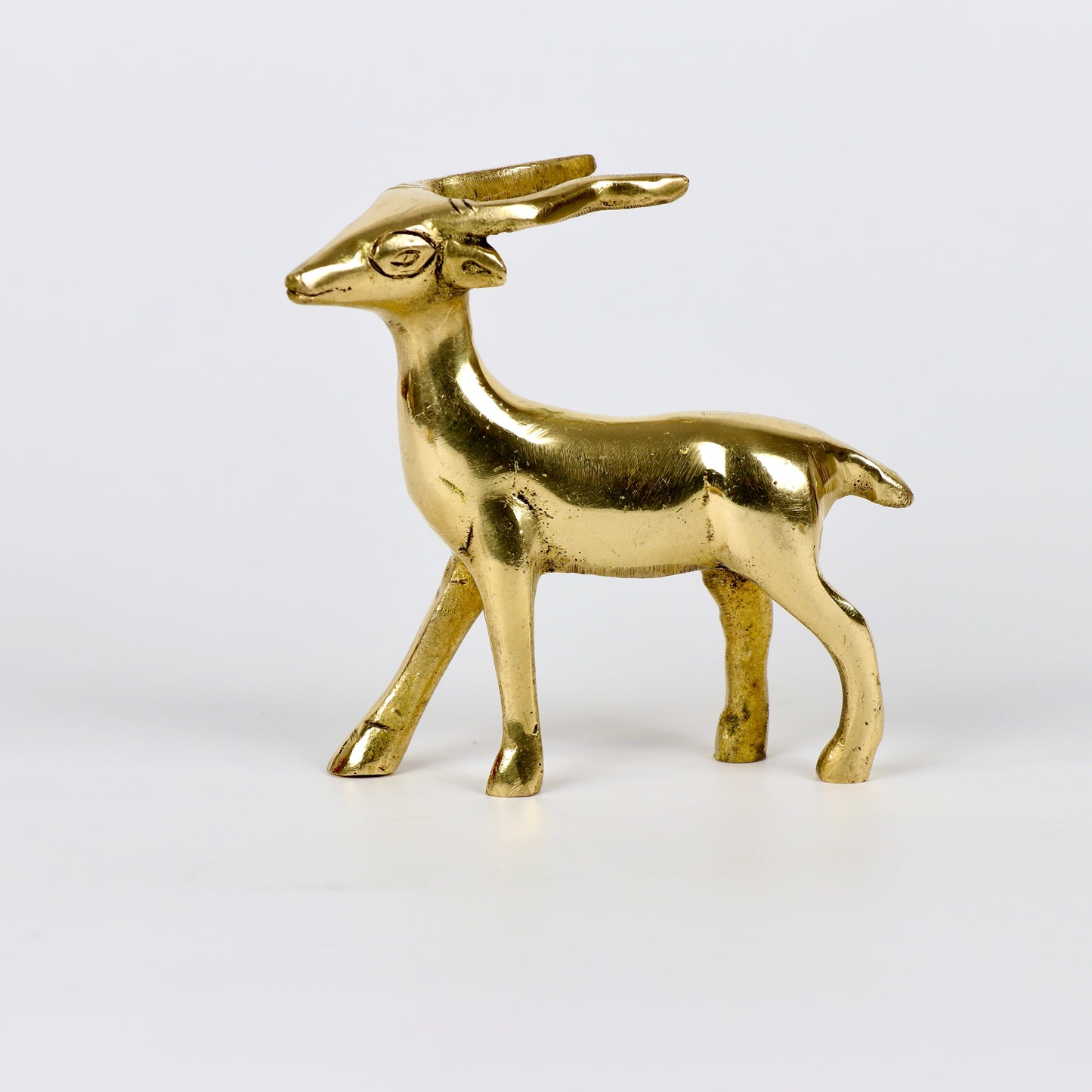 Image of a brass deer statue, elegantly designed with intricate detailing. The deer is depicted in a graceful standing posture, symbolizing peace, harmony, and gentleness. Crafted from polished brass, this statue is ideal for Vastu, home décor, or gifting to enhance positive energy and elegance in any space.