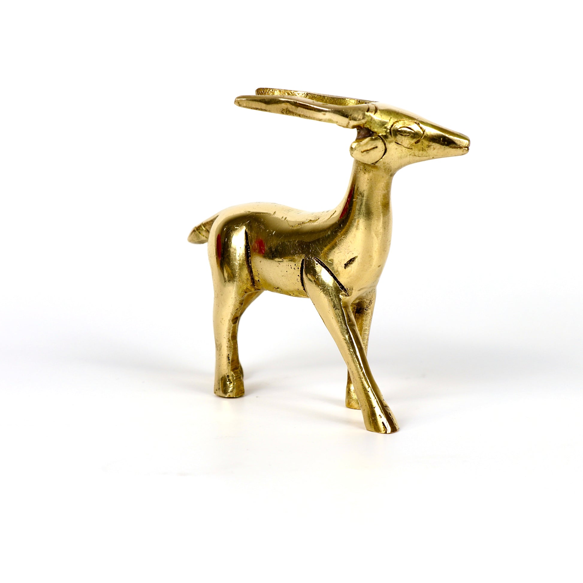 Image of a brass deer statue, elegantly designed with intricate detailing. The deer is depicted in a graceful standing posture, symbolizing peace, harmony, and gentleness. Crafted from polished brass, this statue is ideal for Vastu, home décor, or gifting to enhance positive energy and elegance in any space.