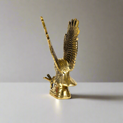 Product image of a Brass Eagle figurine from Indian Impressions, depicting the eagle in a poised stance with outspread wings. Crafted with intricate detailing and a polished brass finish, this piece symbolizes strength, protection, and vision, making it ideal for Vastu, home décor, or gifting.