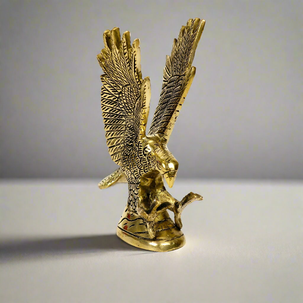 Product image of a Brass Eagle figurine from Indian Impressions, depicting the eagle in a poised stance with outspread wings. Crafted with intricate detailing and a polished brass finish, this piece symbolizes strength, protection, and vision, making it ideal for Vastu, home décor, or gifting.