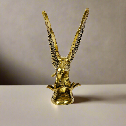 Product image of a Brass Eagle figurine from Indian Impressions, depicting the eagle in a poised stance with outspread wings. Crafted with intricate detailing and a polished brass finish, this piece symbolizes strength, protection, and vision, making it ideal for Vastu, home décor, or gifting.