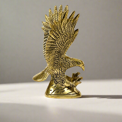 Product image of a Brass Eagle figurine from Indian Impressions, depicting the eagle in a poised stance with outspread wings. Crafted with intricate detailing and a polished brass finish, this piece symbolizes strength, protection, and vision, making it ideal for Vastu, home décor, or gifting.