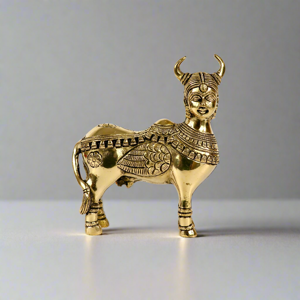 Product image of a Brass Kamdhenu Cow from Indian Impressions, intricately crafted with detailed carvings. The cow is depicted in a standing posture, symbolizing prosperity, abundance, and spiritual significance. Finished in polished brass, this piece is ideal for Vastu, spiritual practices, home décor, or gifting to bring positive energy and blessings to any space.