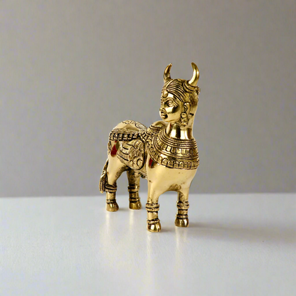 Product image of a Brass Kamdhenu Cow from Indian Impressions, intricately crafted with detailed carvings. The cow is depicted in a standing posture, symbolizing prosperity, abundance, and spiritual significance. Finished in polished brass, this piece is ideal for Vastu, spiritual practices, home décor, or gifting to bring positive energy and blessings to any space.