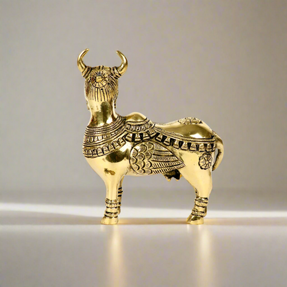 Product image of a Brass Kamdhenu Cow from Indian Impressions, intricately crafted with detailed carvings. The cow is depicted in a standing posture, symbolizing prosperity, abundance, and spiritual significance. Finished in polished brass, this piece is ideal for Vastu, spiritual practices, home décor, or gifting to bring positive energy and blessings to any space.