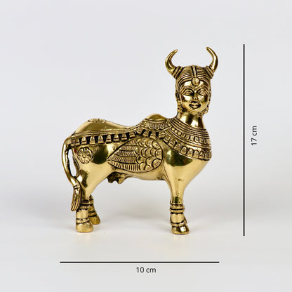 Product image of a Brass Kamdhenu Cow from Indian Impressions, intricately crafted with detailed carvings. The cow is depicted in a standing posture, symbolizing prosperity, abundance, and spiritual significance. Finished in polished brass, this piece is ideal for Vastu, spiritual practices, home décor, or gifting to bring positive energy and blessings to any space.