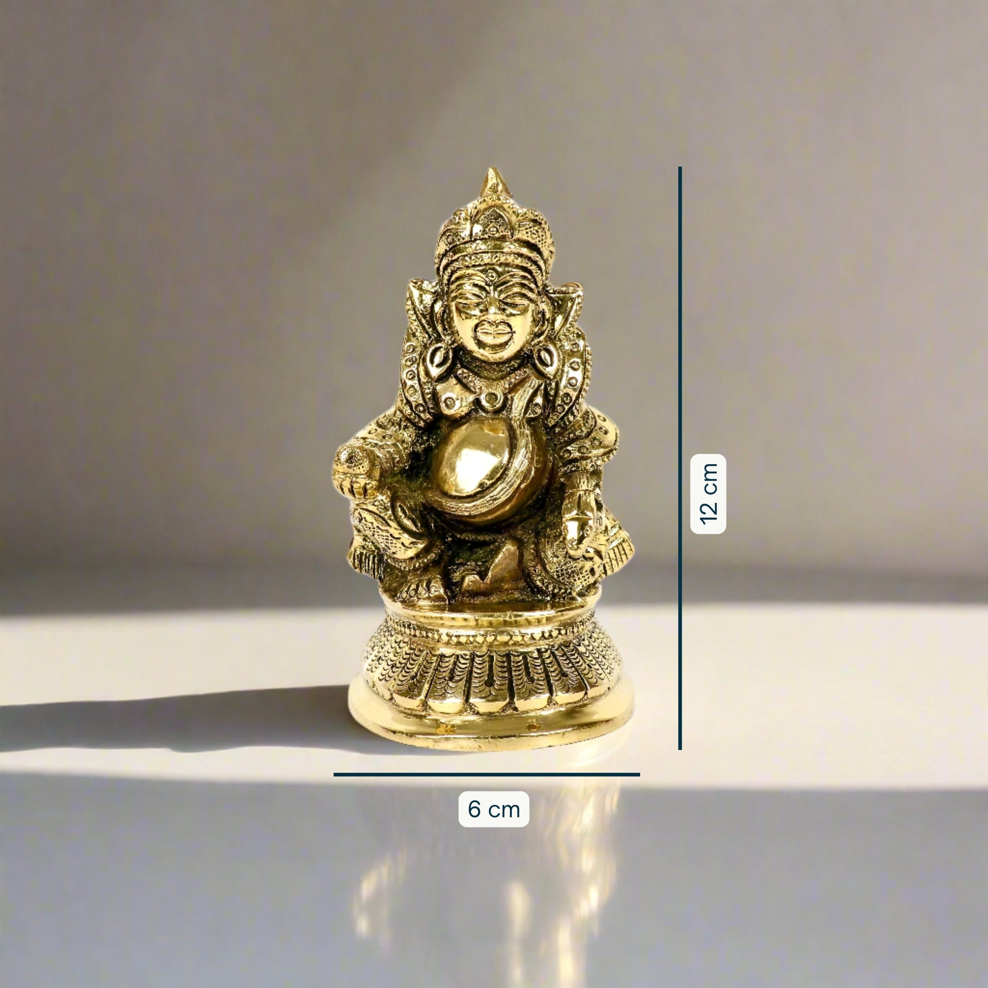 Product image of a Brass Kuber Idol from Indian Impressions, featuring Lord Kuber, the deity of wealth, seated gracefully with a pot of treasures. The idol is intricately crafted with fine details and a polished brass finish, making it perfect for Vastu, spiritual practices, home décor, or gifting to attract prosperity and abundance.