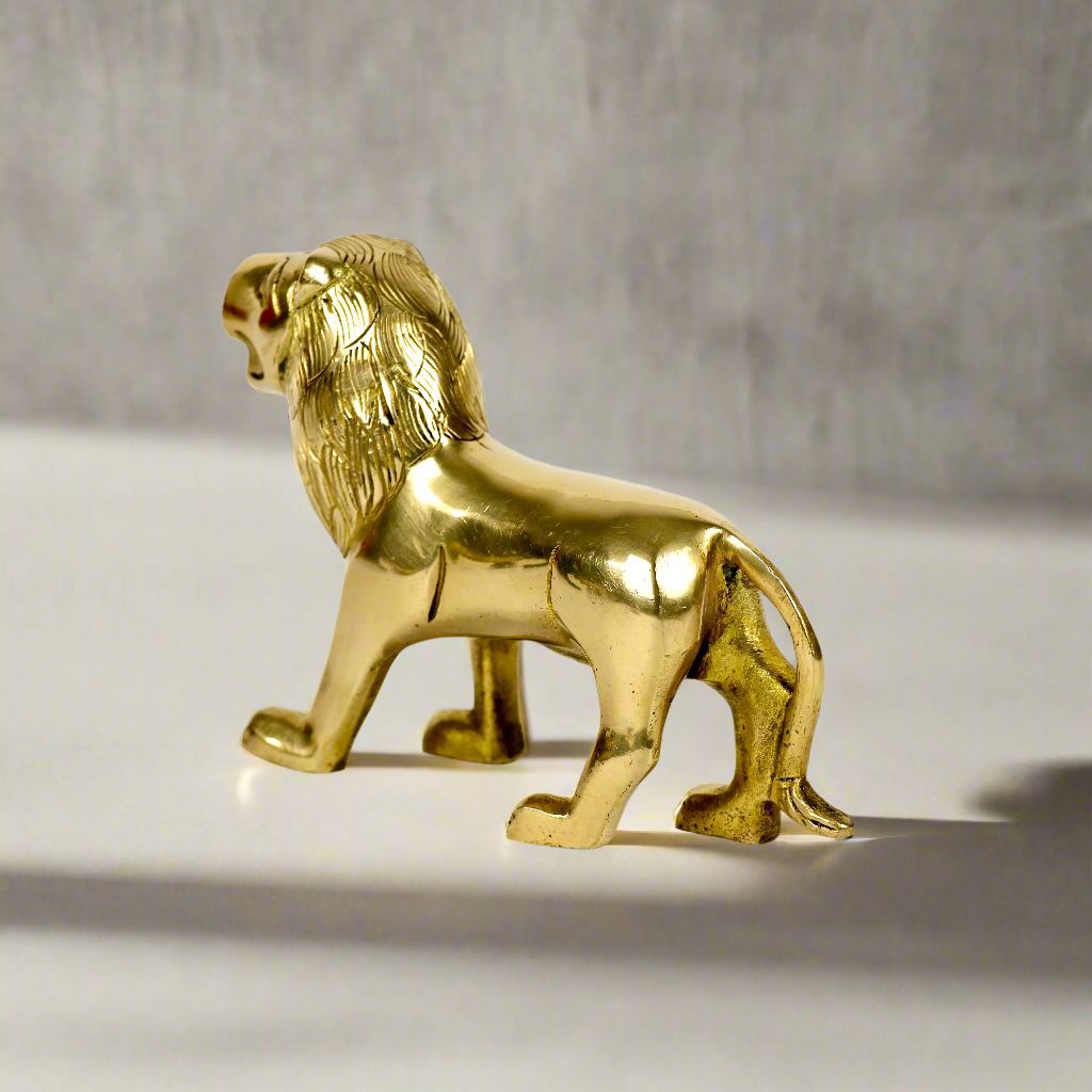 Product image of a Brass Lion figurine from Indian Impressions, showcasing a majestic lion in a poised stance with intricate detailing. Symbolizing strength, courage, and protection, the polished brass finish enhances its regal appeal. Perfect for Vastu, home décor, or gifting to bring power and positive energy to any space.