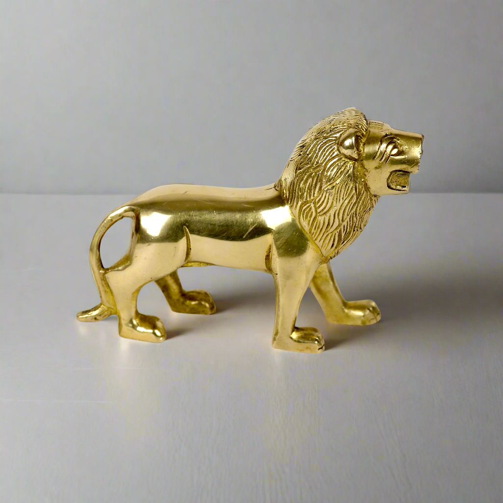 Product image of a Brass Lion figurine from Indian Impressions, showcasing a majestic lion in a poised stance with intricate detailing. Symbolizing strength, courage, and protection, the polished brass finish enhances its regal appeal. Perfect for Vastu, home décor, or gifting to bring power and positive energy to any space.