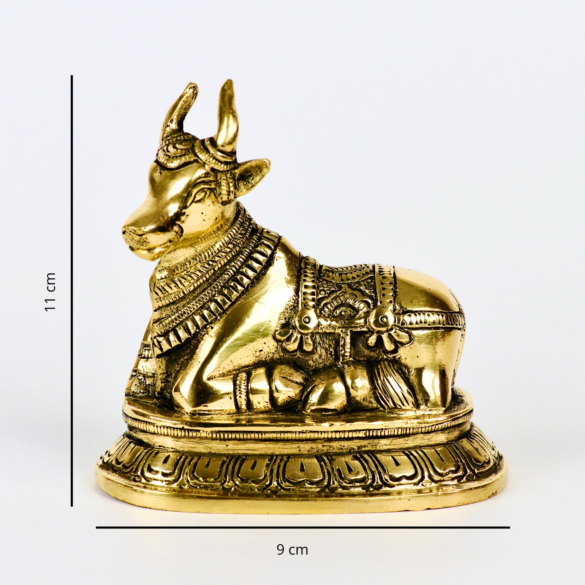 Product image of a Brass Nandi Ji from Indian Impressions, depicting the sacred bull in a seated posture with intricate detailing. Crafted from polished brass, this idol symbolizes devotion, strength, and positivity. Ideal for Vastu, spiritual practices, home décor, or gifting to bring blessings and harmony to any space.