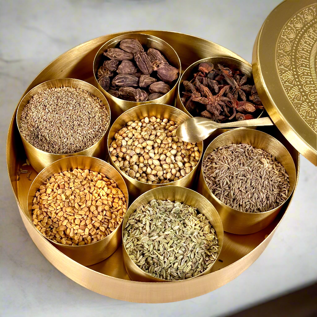 Product image of a Brass Spice Box from Indian Impressions, featuring a traditional round design with multiple compartments for storing spices. Crafted from polished brass with intricate detailing, this spice box is both functional and decorative, ideal for enhancing Vastu energy, kitchen aesthetics, or gifting.