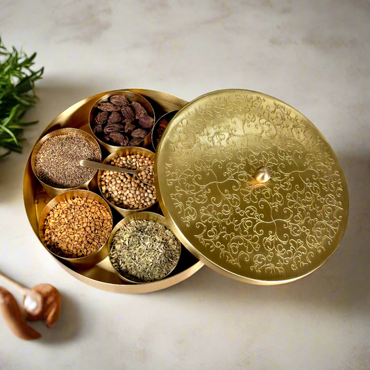 Product image of a Brass Spice Box from Indian Impressions, featuring a traditional round design with multiple compartments for storing spices. Crafted from polished brass with intricate detailing, this spice box is both functional and decorative, ideal for enhancing Vastu energy, kitchen aesthetics, or gifting.