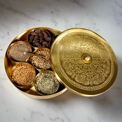 Product image of a Brass Spice Box from Indian Impressions, featuring a traditional round design with multiple compartments for storing spices. Crafted from polished brass with intricate detailing, this spice box is both functional and decorative, ideal for enhancing Vastu energy, kitchen aesthetics, or gifting.