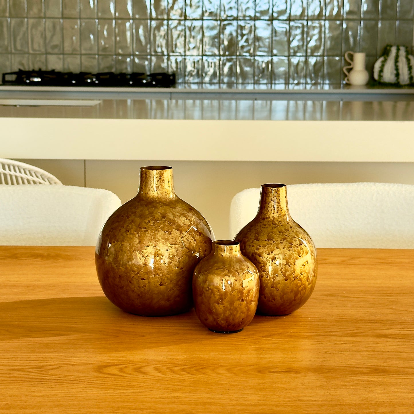 Product image of the Metal Bud Vase Set of 3 in Antique Gold from Indian Impressions, featuring a trio of elegantly designed vases with a vintage gold finish. Perfect for displaying single stems or as standalone décor pieces, these vases are ideal for Vastu, home décor, or gifting, adding a sophisticated and timeless touch to any space.