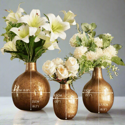 Product image of the Metal Bud Vase Set of 3 in Antique Gold from Indian Impressions, featuring a trio of elegantly designed vases with a vintage gold finish. Perfect for displaying single stems or as standalone décor pieces, these vases are ideal for Vastu, home décor, or gifting, adding a sophisticated and timeless touch to any space.