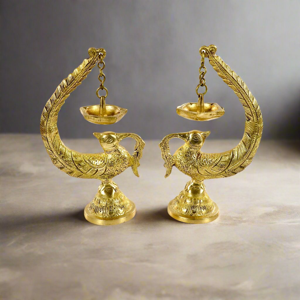 Image of a brass Bulbul Diya, featuring an elegant bird-shaped design with intricate carvings. The diya showcases a deep bowl for holding oil or ghee, complemented by a polished brass finish that adds a traditional charm. Perfect for spiritual rituals, festive décor, or gifting, this diya brings a touch of grace and serenity to any space.