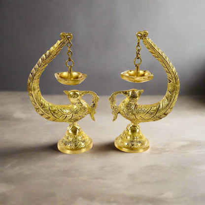 Image of a brass Bulbul Diya, featuring an elegant bird-shaped design with intricate carvings. The diya showcases a deep bowl for holding oil or ghee, complemented by a polished brass finish that adds a traditional charm. Perfect for spiritual rituals, festive décor, or gifting, this diya brings a touch of grace and serenity to any space.