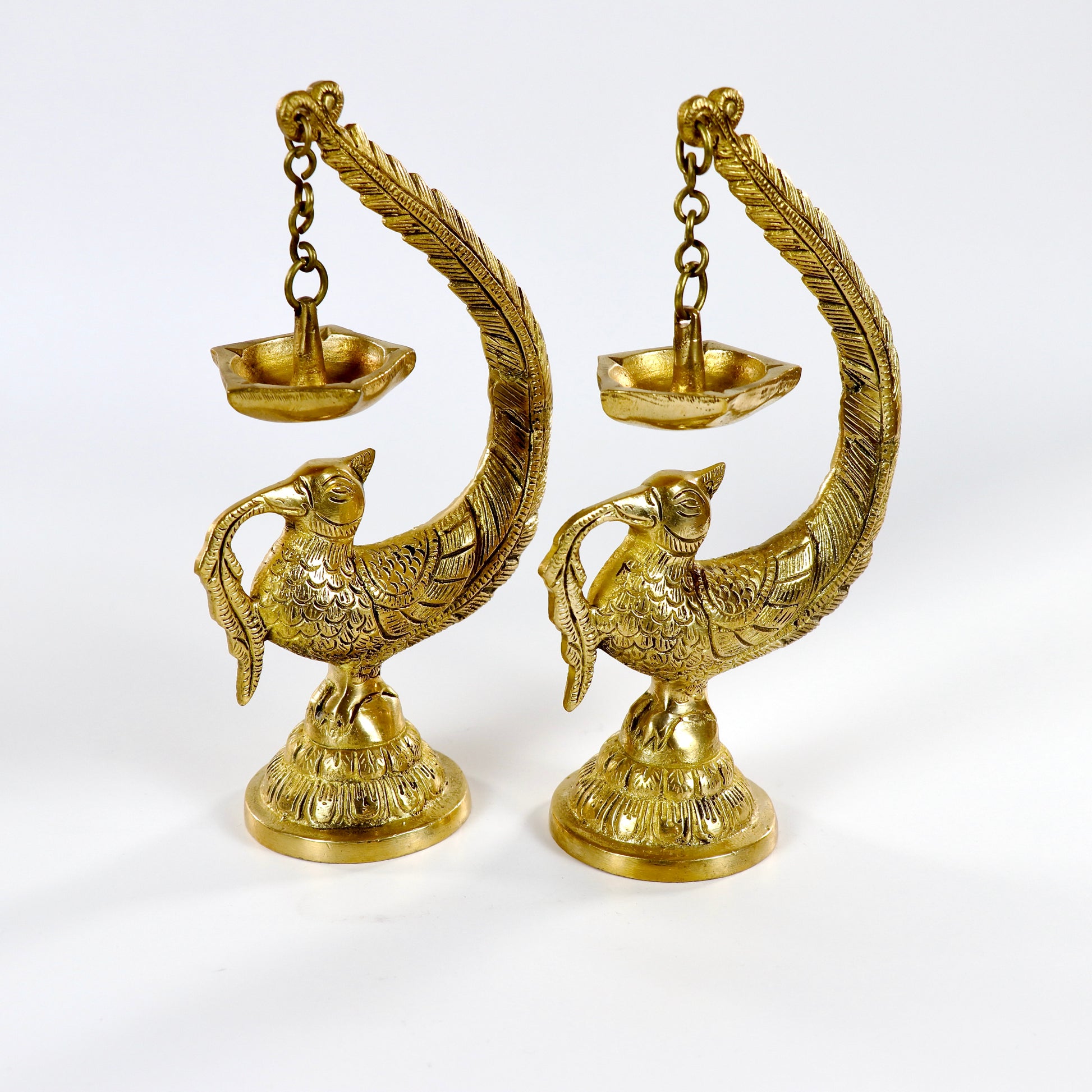 Image of a brass Bulbul Diya, featuring an elegant bird-shaped design with intricate carvings. The diya showcases a deep bowl for holding oil or ghee, complemented by a polished brass finish that adds a traditional charm. Perfect for spiritual rituals, festive décor, or gifting, this diya brings a touch of grace and serenity to any space.