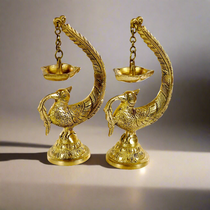 Image of a brass Bulbul Diya, featuring an elegant bird-shaped design with intricate carvings. The diya showcases a deep bowl for holding oil or ghee, complemented by a polished brass finish that adds a traditional charm. Perfect for spiritual rituals, festive décor, or gifting, this diya brings a touch of grace and serenity to any space.