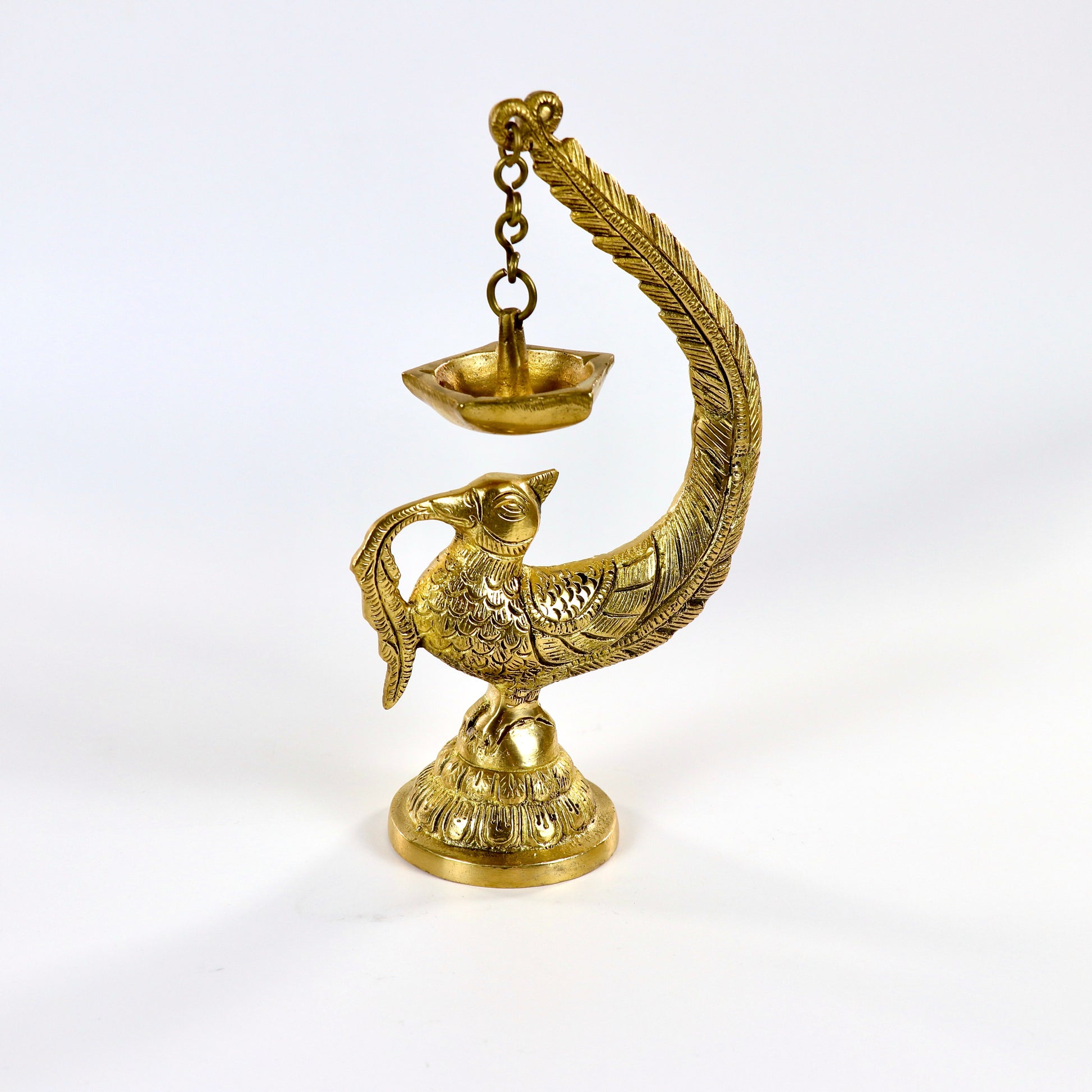 Image of a brass Bulbul Diya, featuring an elegant bird-shaped design with intricate carvings. The diya showcases a deep bowl for holding oil or ghee, complemented by a polished brass finish that adds a traditional charm. Perfect for spiritual rituals, festive décor, or gifting, this diya brings a touch of grace and serenity to any space.