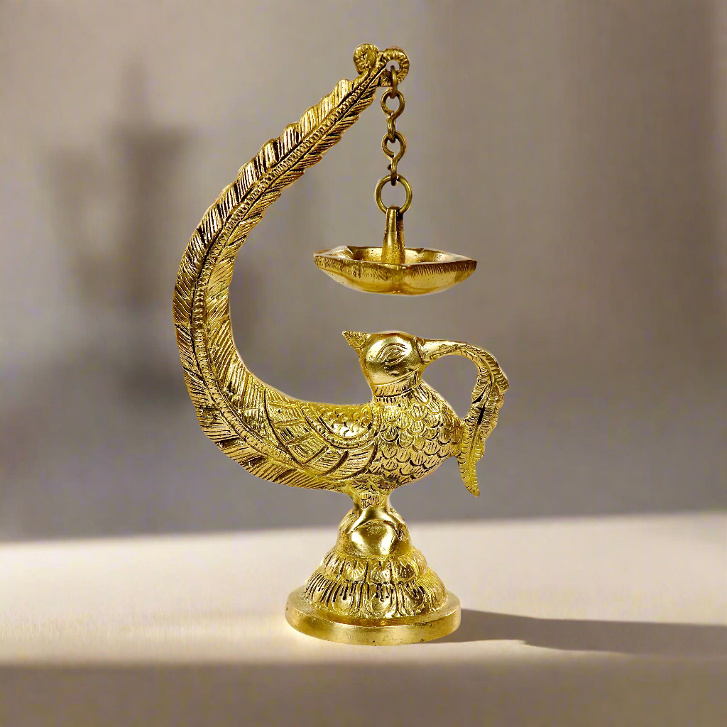 Image of a brass Bulbul Diya, featuring an elegant bird-shaped design with intricate carvings. The diya showcases a deep bowl for holding oil or ghee, complemented by a polished brass finish that adds a traditional charm. Perfect for spiritual rituals, festive décor, or gifting, this diya brings a touch of grace and serenity to any space.