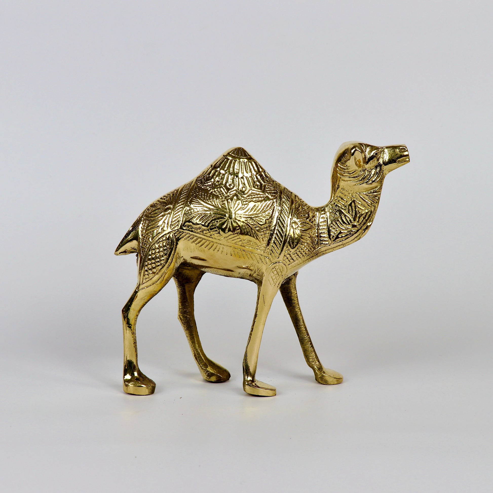 Product image of a Brass Camel figurine from Indian Impressions, intricately crafted with detailed features. The camel is depicted in a standing posture, symbolizing endurance and strength. Finished with a polished brass shine, this decorative piece is ideal for Vastu, home décor, or gifting.