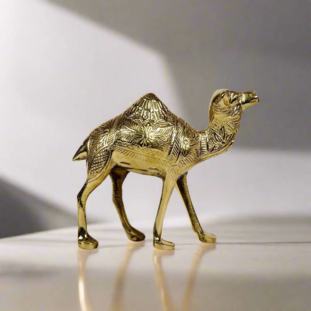 Product image of a Brass Camel figurine from Indian Impressions, intricately crafted with detailed features. The camel is depicted in a standing posture, symbolizing endurance and strength. Finished with a polished brass shine, this decorative piece is ideal for Vastu, home décor, or gifting.