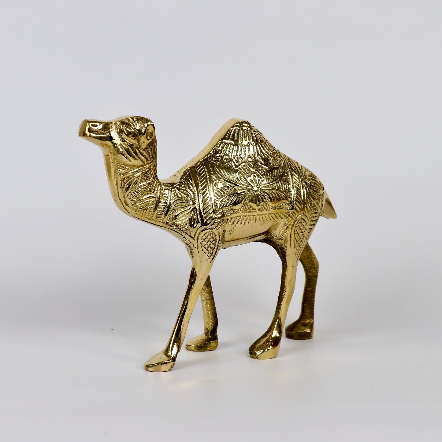 Product image of a Brass Camel figurine from Indian Impressions, intricately crafted with detailed features. The camel is depicted in a standing posture, symbolizing endurance and strength. Finished with a polished brass shine, this decorative piece is ideal for Vastu, home décor, or gifting.