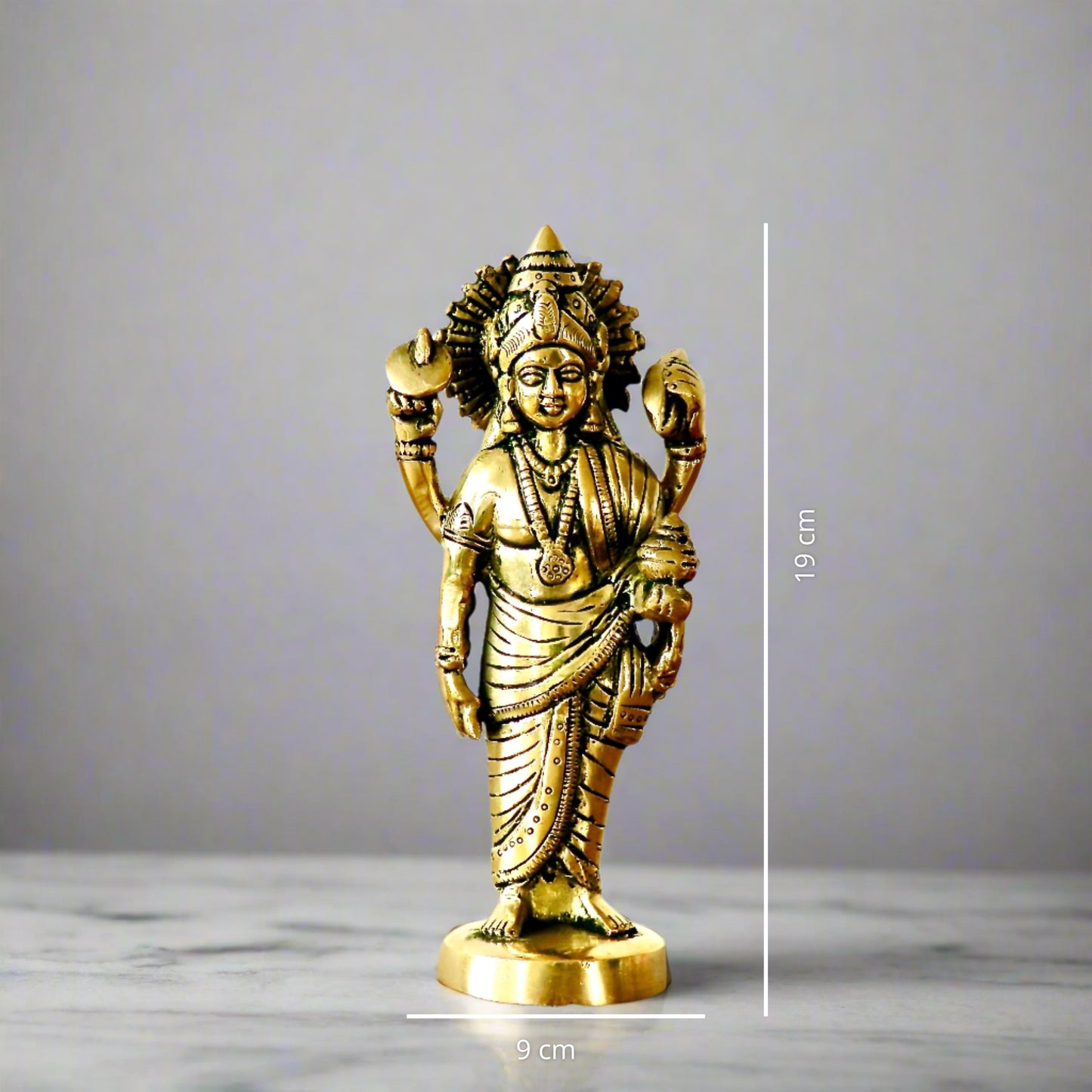 Product image of a Brass Dhanvantri Idol from Indian Impressions, showcasing Lord Dhanvantri in a standing posture holding sacred items. The idol is intricately crafted with fine details and features a polished brass finish, ideal for Vastu, spiritual practices, home décor, or gifting to promote health and well-being.