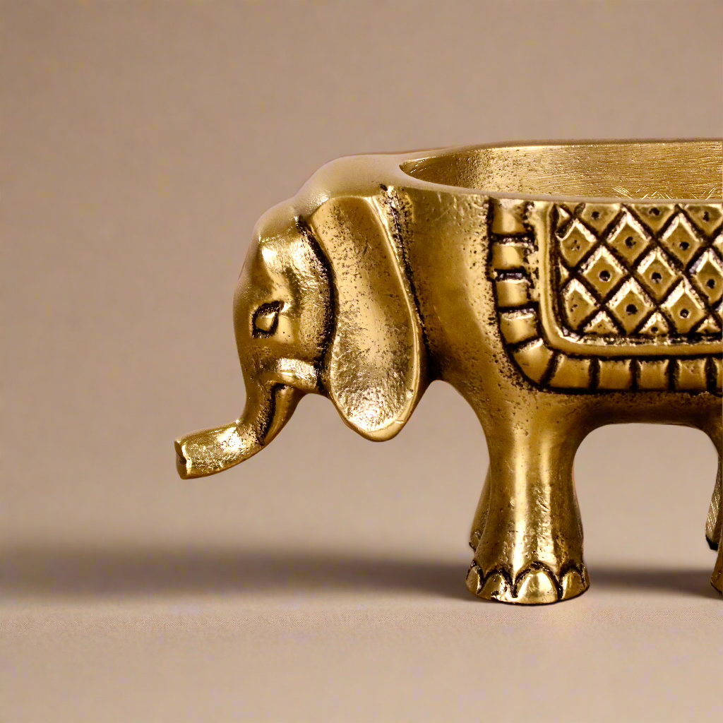 Product image of an Elephant Antique Brass Finish figurine from Indian Impressions, intricately crafted with detailed features. The elephant, symbolizing strength, wisdom, and good luck, is finished in a rich antique brass tone. The figurine comes with a gift box, making it an ideal gift for home décor, spiritual practices, or Vastu.