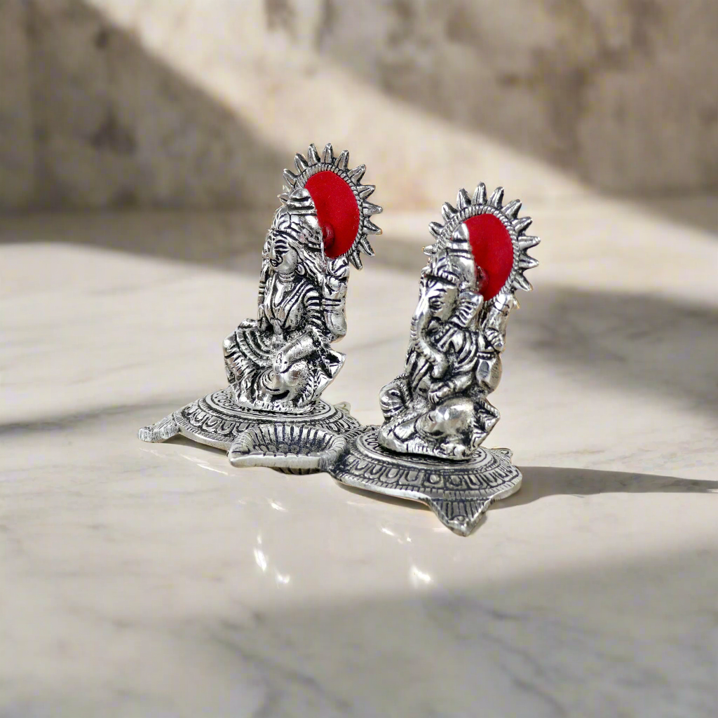 Product image of a Ganesh Lakshmi Gift Set in Silver from Indian Impressions, featuring intricately crafted idols of Lord Ganesha and Goddess Lakshmi. The idols are made with a polished silver finish, symbolizing prosperity, wisdom, and blessings. Ideal for gifting, home décor, or spiritual practices, this set brings divine energy and elegance to any space.