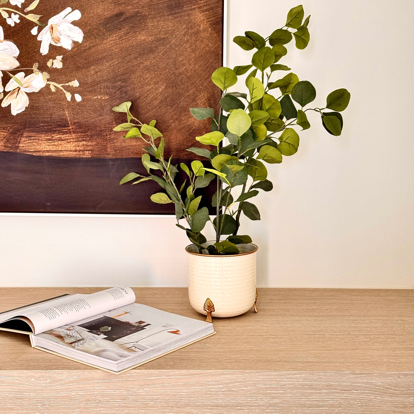 Product image of a Metal Hammered Gold Rim Leaf Leg Planter in White from Indian Impressions, featuring a sleek white body with a hammered texture and a gold rim for an elegant finish. Supported by sturdy leaf-patterned legs, this planter is ideal for enhancing Vastu energy, modern home décor, or gifting, adding sophistication to any space.