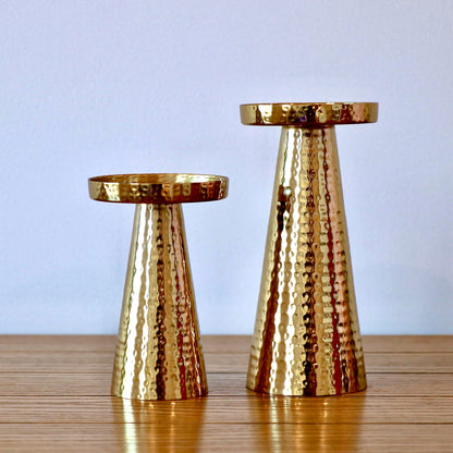 Product image of a Metal Candle Holder Set of 2 from Indian Impressions, featuring elegantly crafted holders with a hammered finish. Designed for pillar or taper candles, these holders add a touch of sophistication to any setting. Perfect for Vastu, home décor, festive occasions, or gifting.