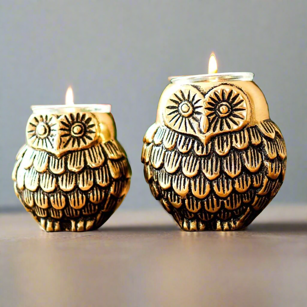 Product image of the Owl Figurine Pair Tea light Holder with Antique Brass Finish from Indian Impressions, featuring two intricately designed owl statues with detailed craftsmanship. Symbolizing wisdom and protection, these figurines are ideal for Vastu, home décor, or gifting, adding a touch of charm and positive energy to any space.