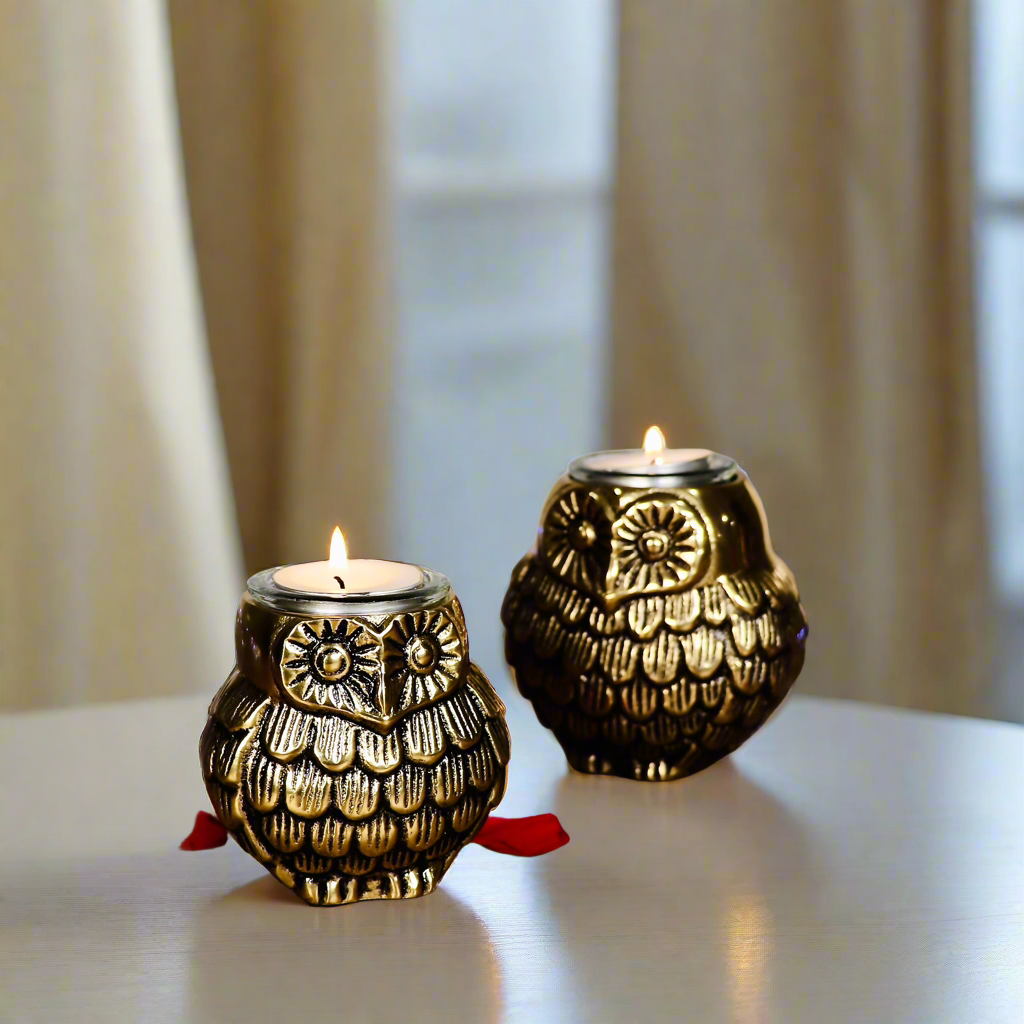 Product image of the Owl Figurine Pair Tea light Holder with Antique Brass Finish from Indian Impressions, featuring two intricately designed owl statues with detailed craftsmanship. Symbolizing wisdom and protection, these figurines are ideal for Vastu, home décor, or gifting, adding a touch of charm and positive energy to any space.