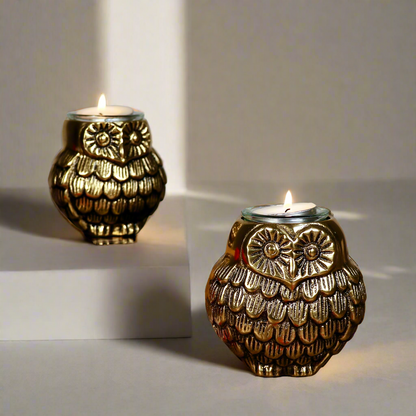 Product image of the Owl Figurine Pair Tea light Holder with Antique Brass Finish from Indian Impressions, featuring two intricately designed owl statues with detailed craftsmanship. Symbolizing wisdom and protection, these figurines are ideal for Vastu, home décor, or gifting, adding a touch of charm and positive energy to any space.