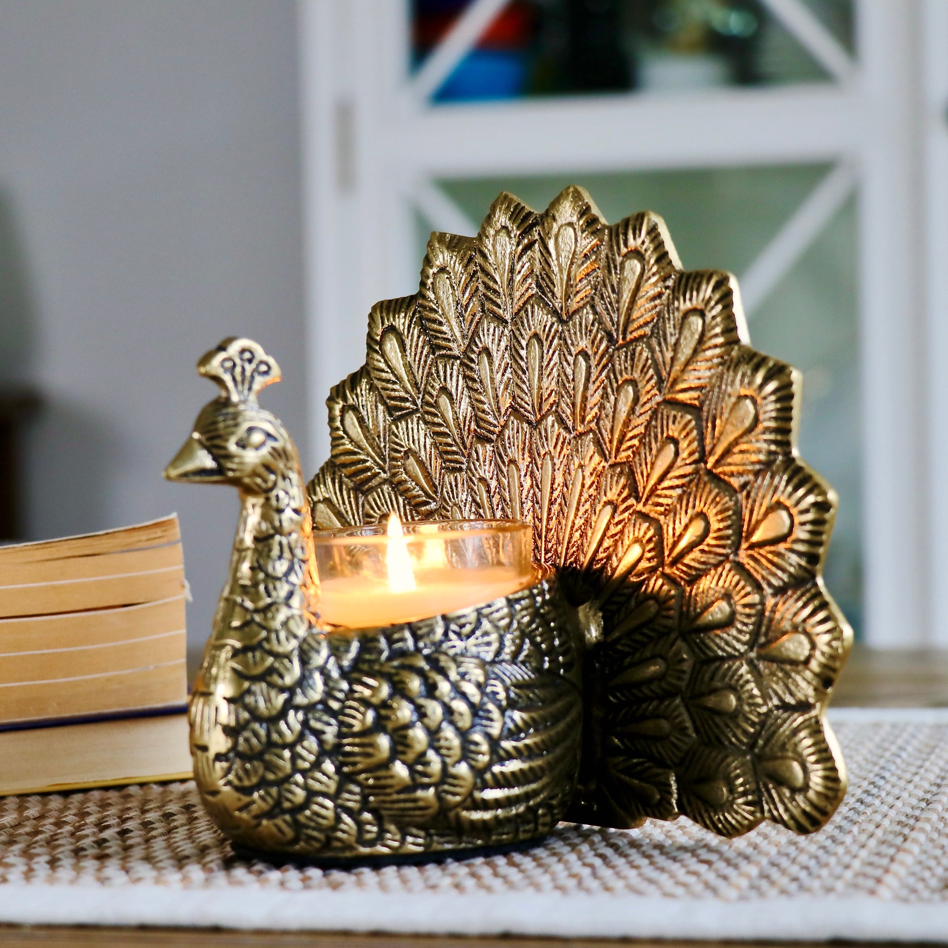 Product image of the Peacock Candle Holder with Antique Brass Finish from Indian Impressions, showcasing a stunning peacock design with intricate detailing and a vintage-inspired finish. Ideal for holding candles, this piece is perfect for Vastu, home décor, festive occasions, or gifting, adding elegance and positive energy to any space.