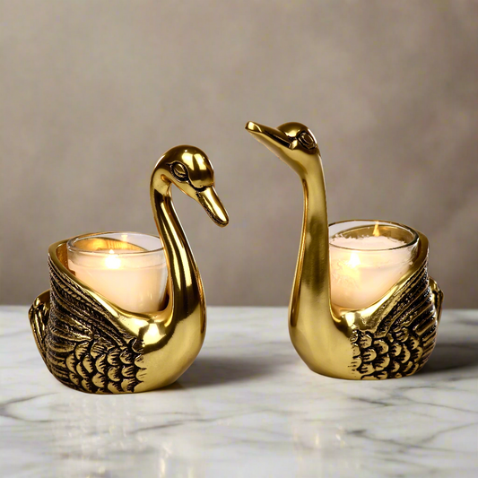 Product image of the Swan Figurine Candle Holder Pair in Gold from Indian Impressions, showcasing two intricately crafted swan-shaped candle holders with a polished gold finish. Ideal for holding candles, this elegant pair is perfect for Vastu, home décor, festive occasions, or gifting, adding sophistication and charm to any space.