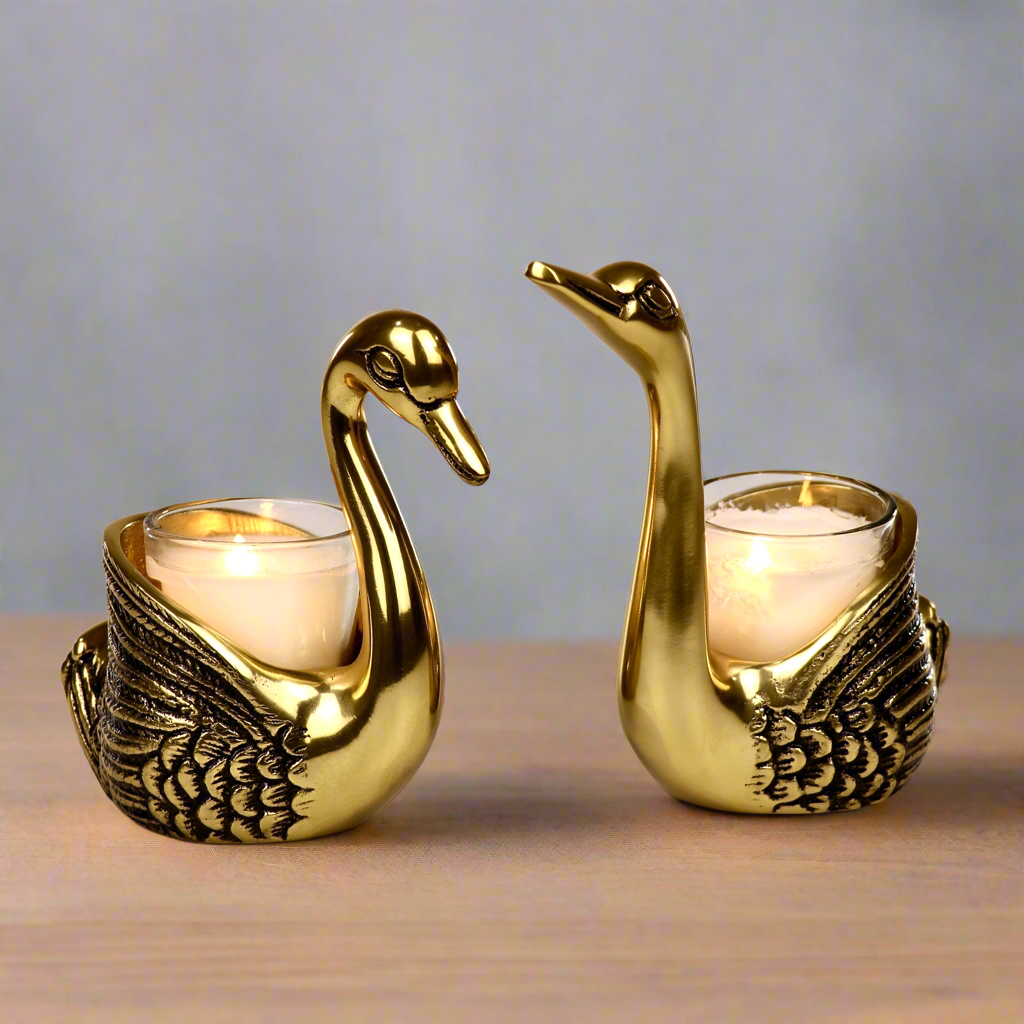 Product image of the Swan Figurine Candle Holder Pair in Gold from Indian Impressions, showcasing two intricately crafted swan-shaped candle holders with a polished gold finish. Ideal for holding candles, this elegant pair is perfect for Vastu, home décor, festive occasions, or gifting, adding sophistication and charm to any space.