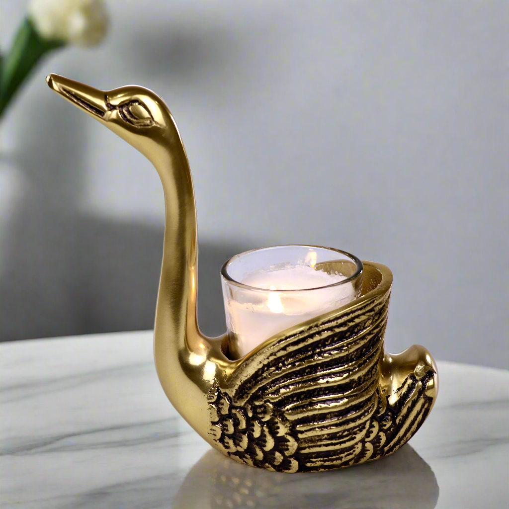 Product image of the Swan Figurine Candle Holder Pair in Gold from Indian Impressions, showcasing two intricately crafted swan-shaped candle holders with a polished gold finish. Ideal for holding candles, this elegant pair is perfect for Vastu, home décor, festive occasions, or gifting, adding sophistication and charm to any space.