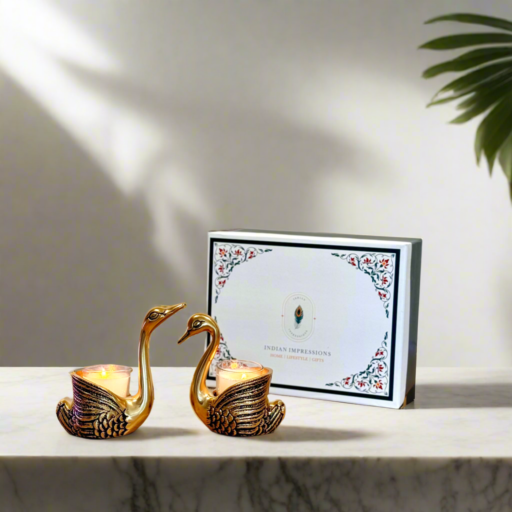 Product image of the Swan Figurine Candle Holder Pair in Gold from Indian Impressions, showcasing two intricately crafted swan-shaped candle holders with a polished gold finish. Ideal for holding candles, this elegant pair is perfect for Vastu, home décor, festive occasions, or gifting, adding sophistication and charm to any space.