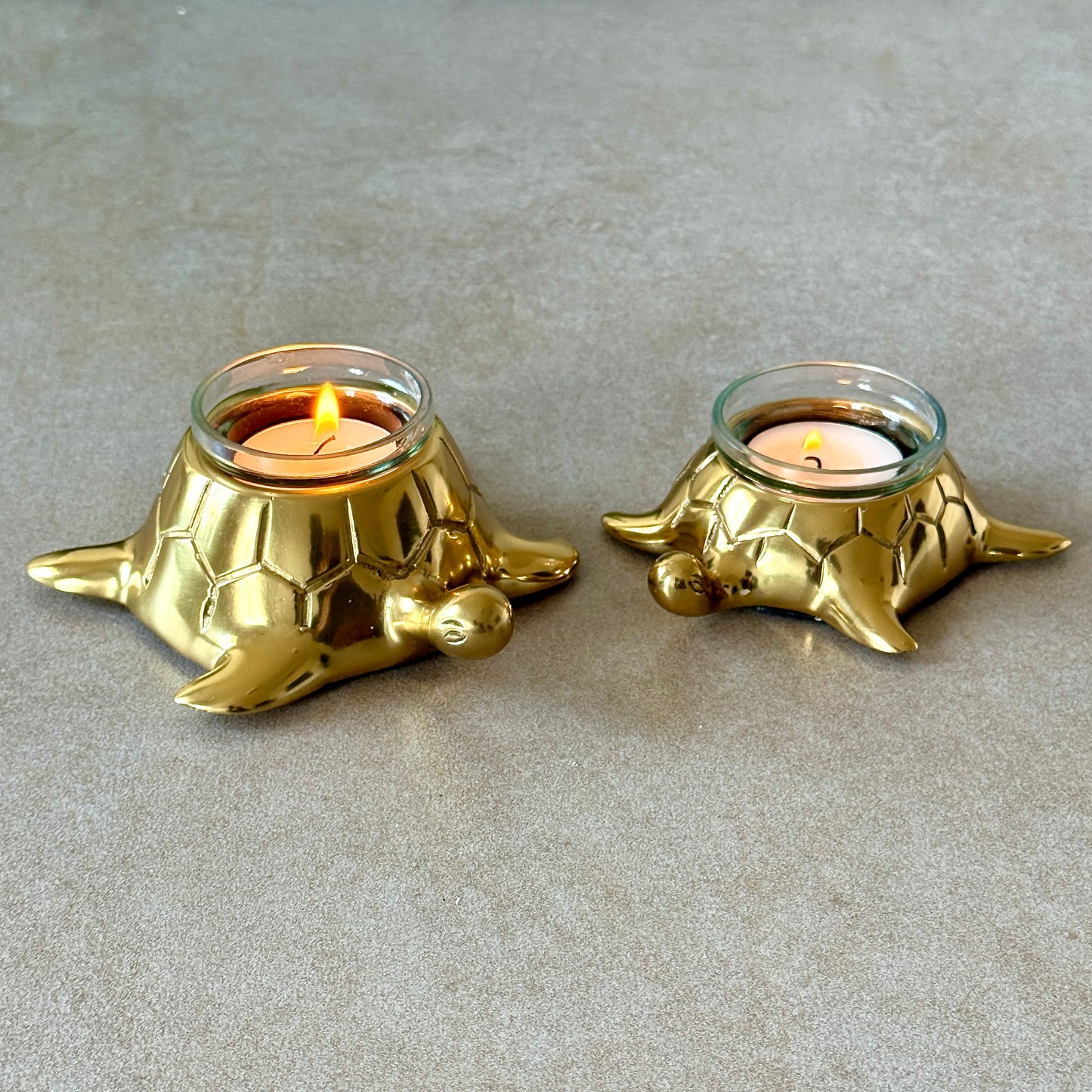 Product image of the Turtle Candle Holder Pair in Gold from Indian Impressions, featuring two beautifully crafted turtle-shaped candle holders with a polished gold finish. Ideal for holding candles, this pair symbolizes stability and longevity. Perfect for Vastu, home décor, or gifting, adding elegance and positive energy to any space.