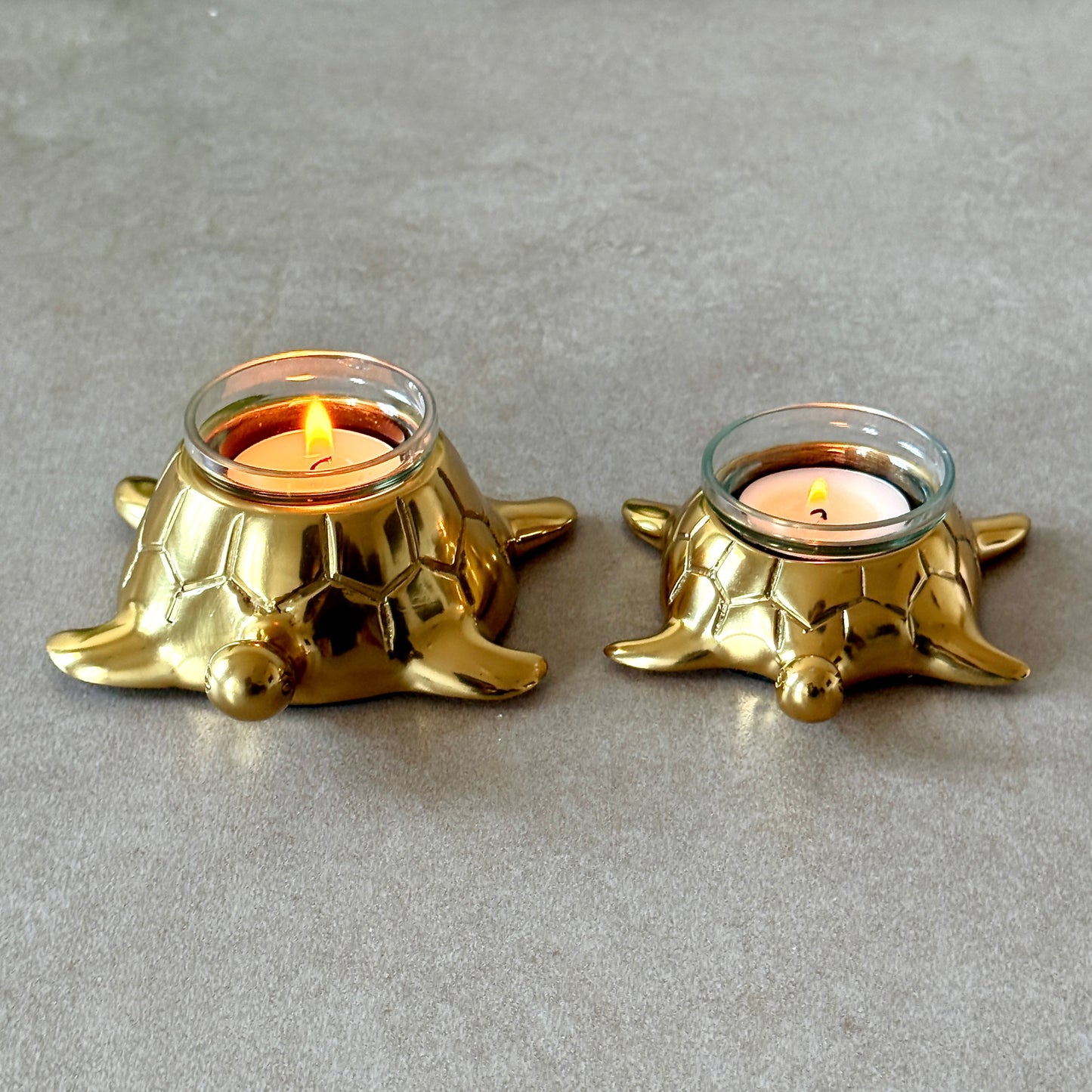 Product image of the Turtle Candle Holder Pair in Gold from Indian Impressions, featuring two beautifully crafted turtle-shaped candle holders with a polished gold finish. Ideal for holding candles, this pair symbolizes stability and longevity. Perfect for Vastu, home décor, or gifting, adding elegance and positive energy to any space.